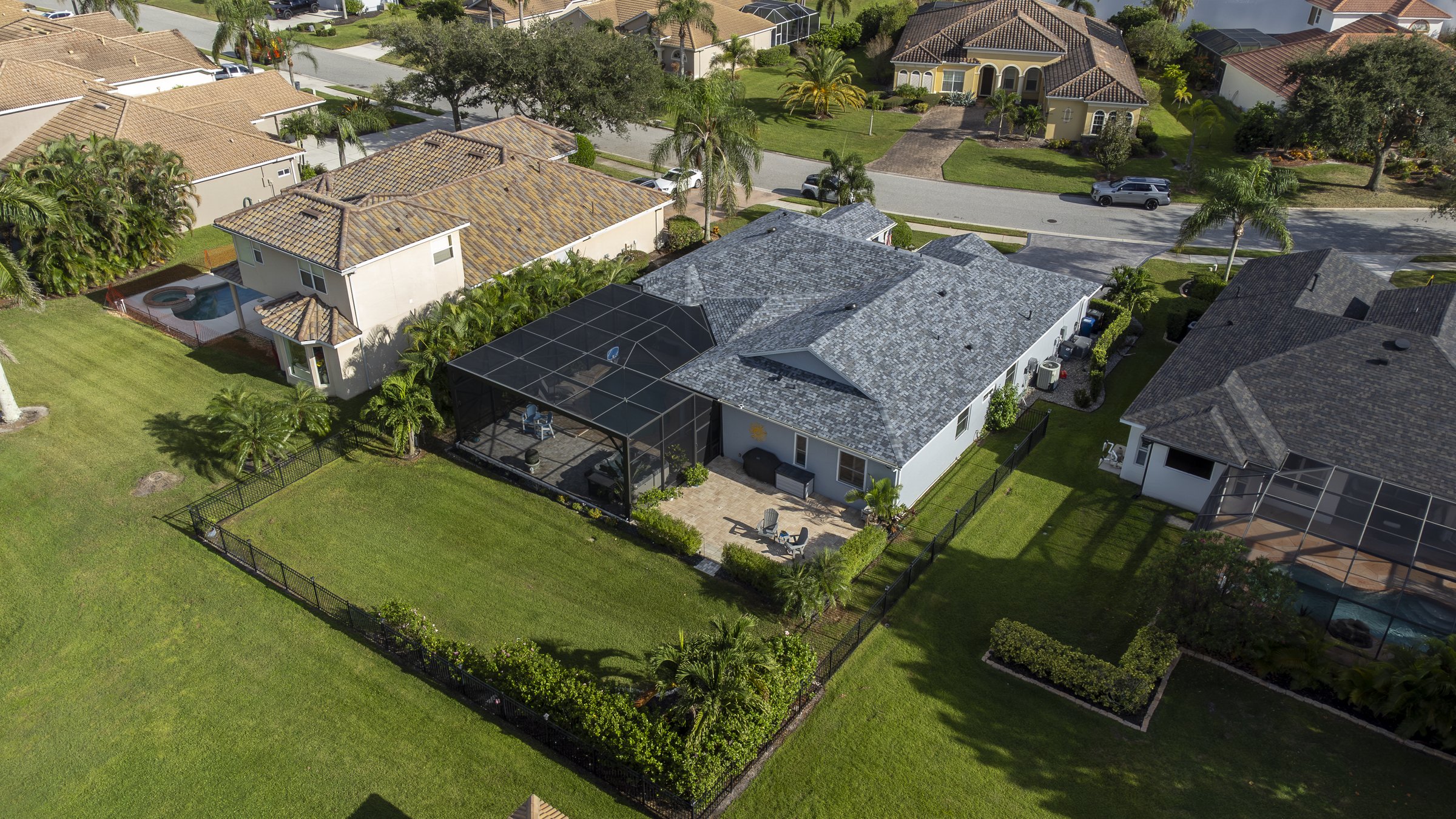 Backyard drone aerial of a Sarasota luxury home with screened lanai