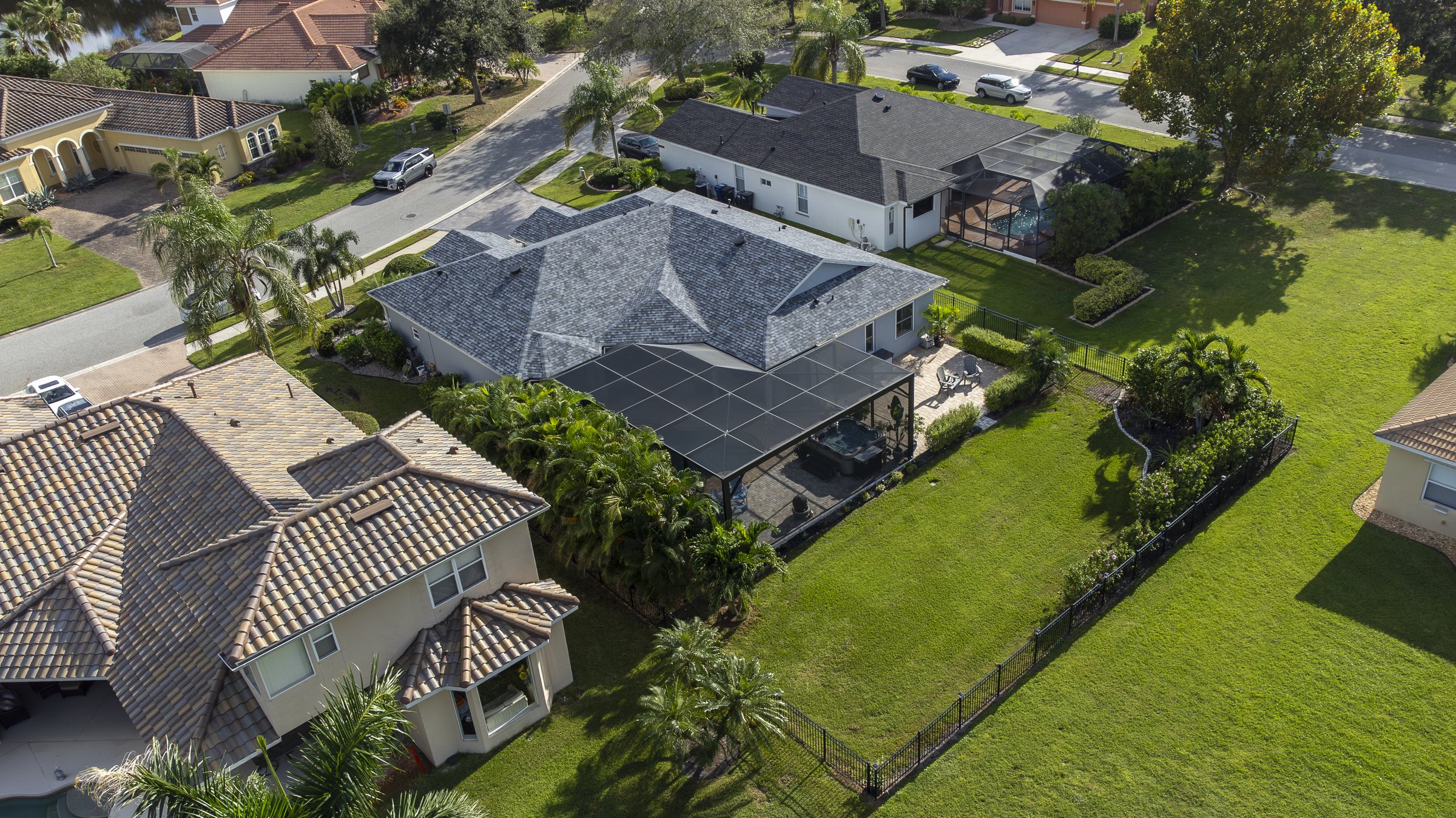 Drone aerial of a Sarasota home with screened pool cage and lush yard