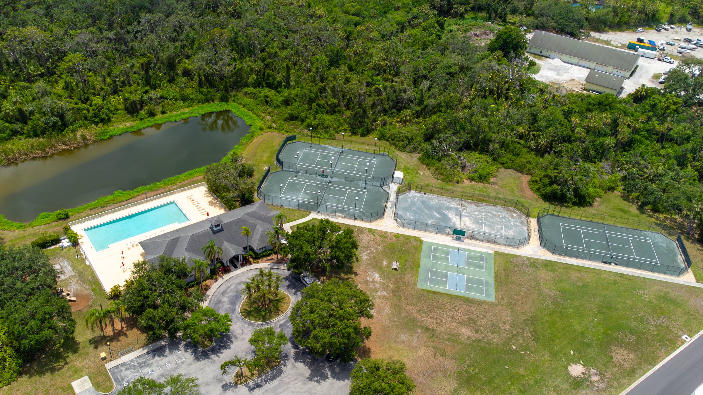 Top-down drone aerial of community pool and tennis courts in Sarasota
