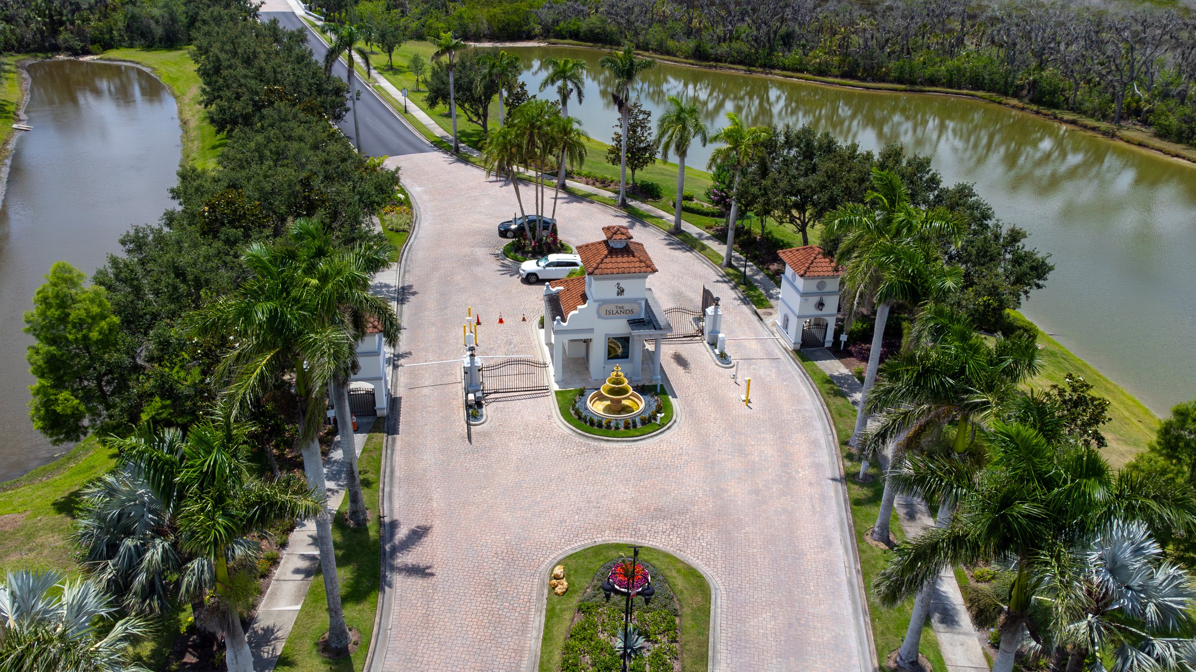 Gated community entry with palm-lined drive — Sarasota Florida drone photography