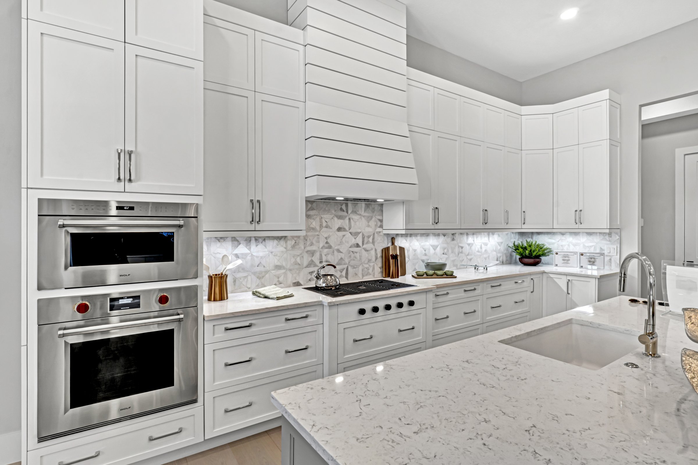Chef's kitchen with custom range hood and marble counters in a Sarasota luxury home